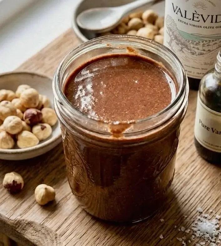 Homemade cacao and hazelnut spread in a glass jar with a spoon