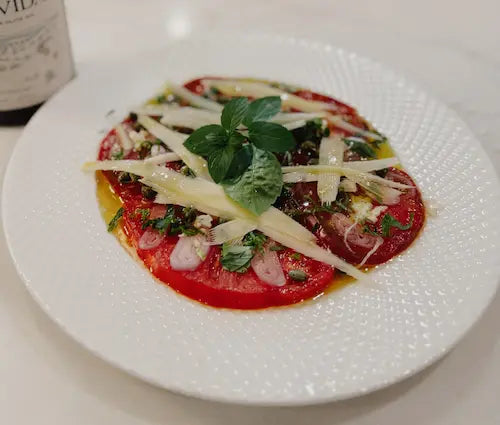 Thinly sliced heirloom tomato with shaved parmesan, garlic and extra virgin olive oil