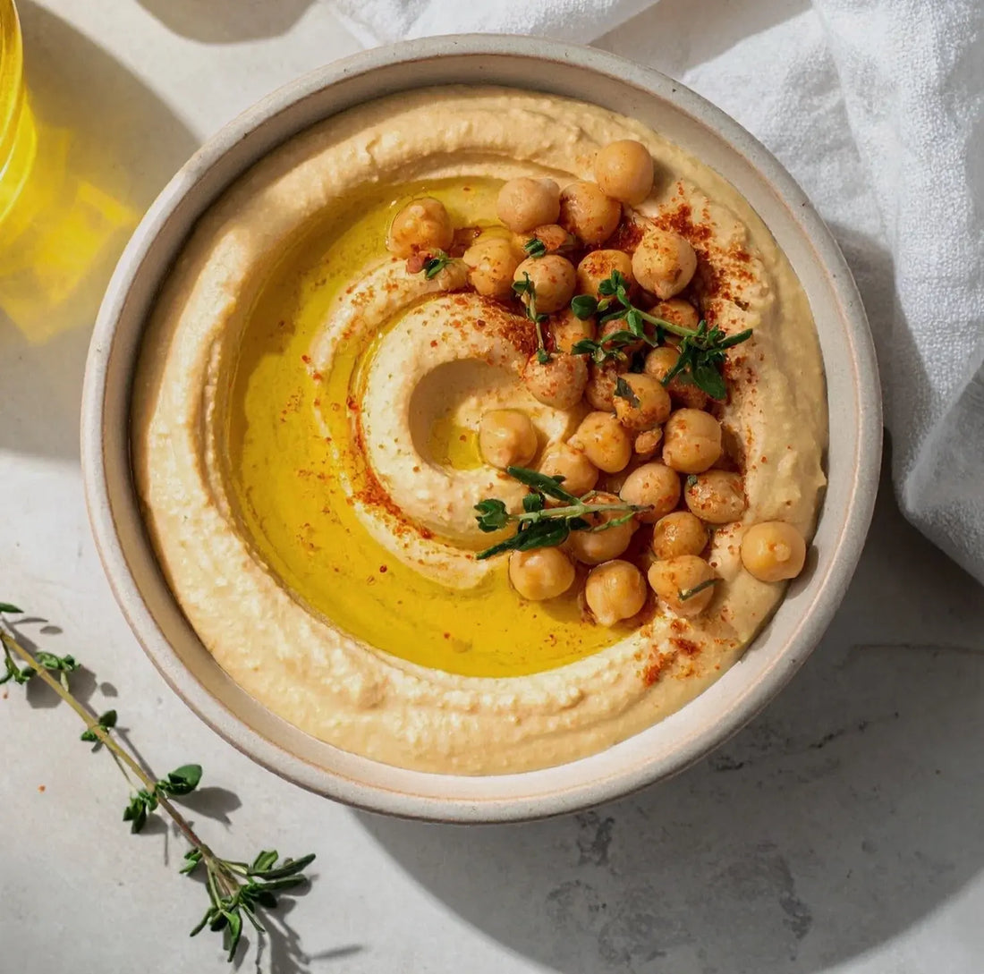 Creamy hummus swirled in a bowl and finished with extra virgin olive oil
